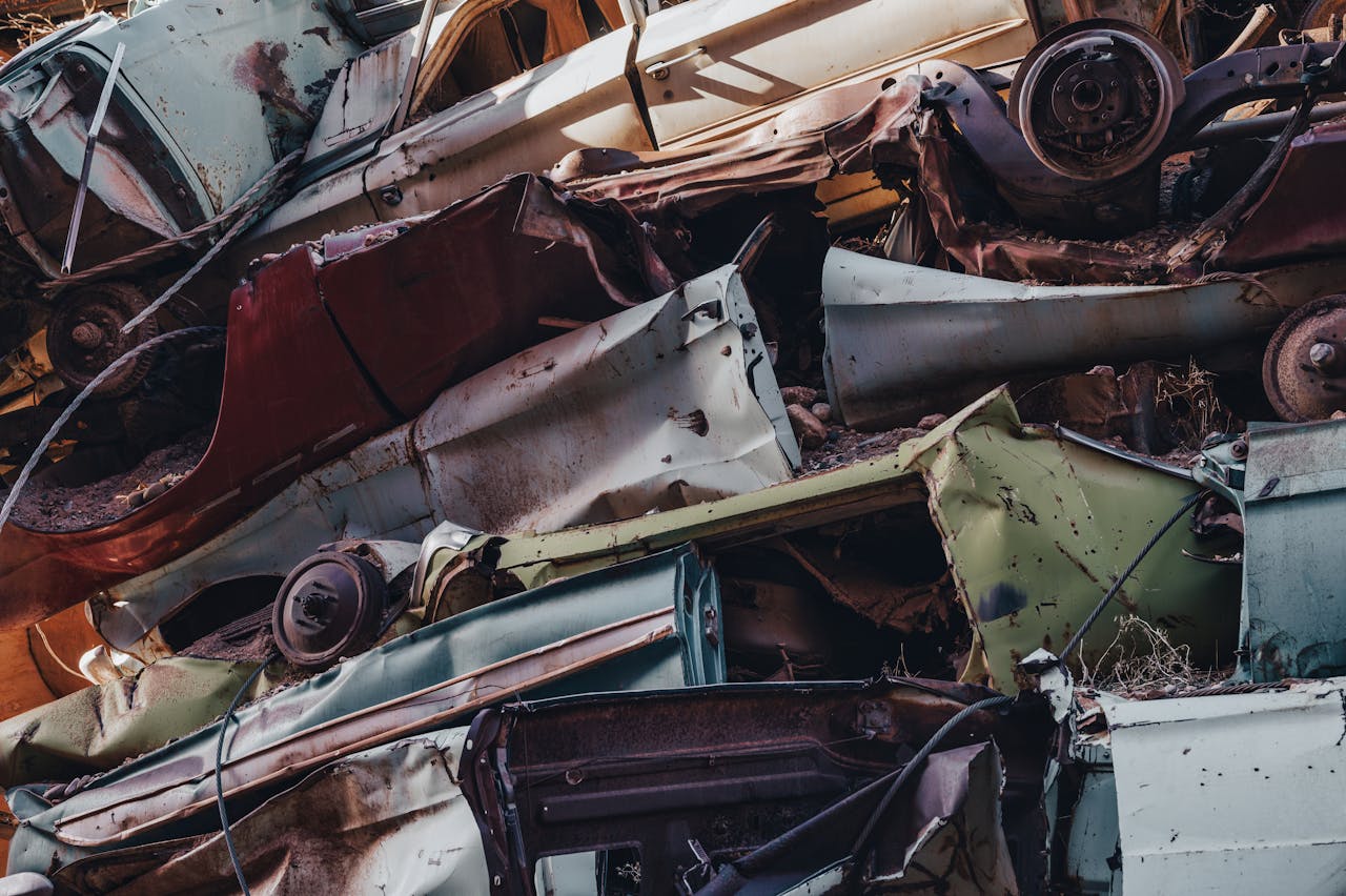 Services-02 Close-up view of rusted cars stacked in a junkyard, showcasing decay and waste.