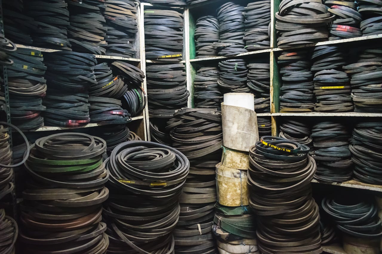 Services-03 A cluttered storage room filled with stacks of rubber belts and industrial equipment.