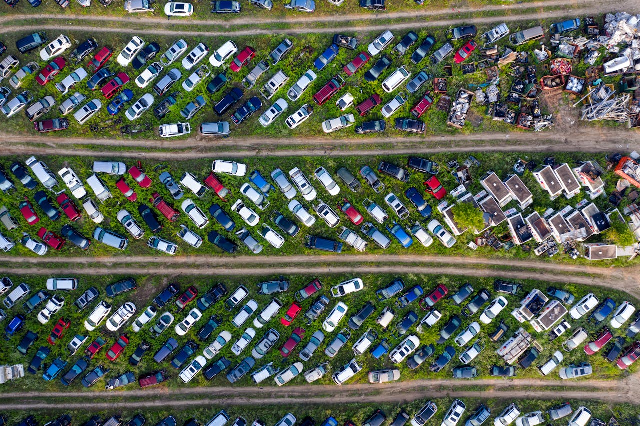 Services-01 Top view of a busy scrapyard in Saint Charles filled with rows of abandoned vehicles and metal parts.